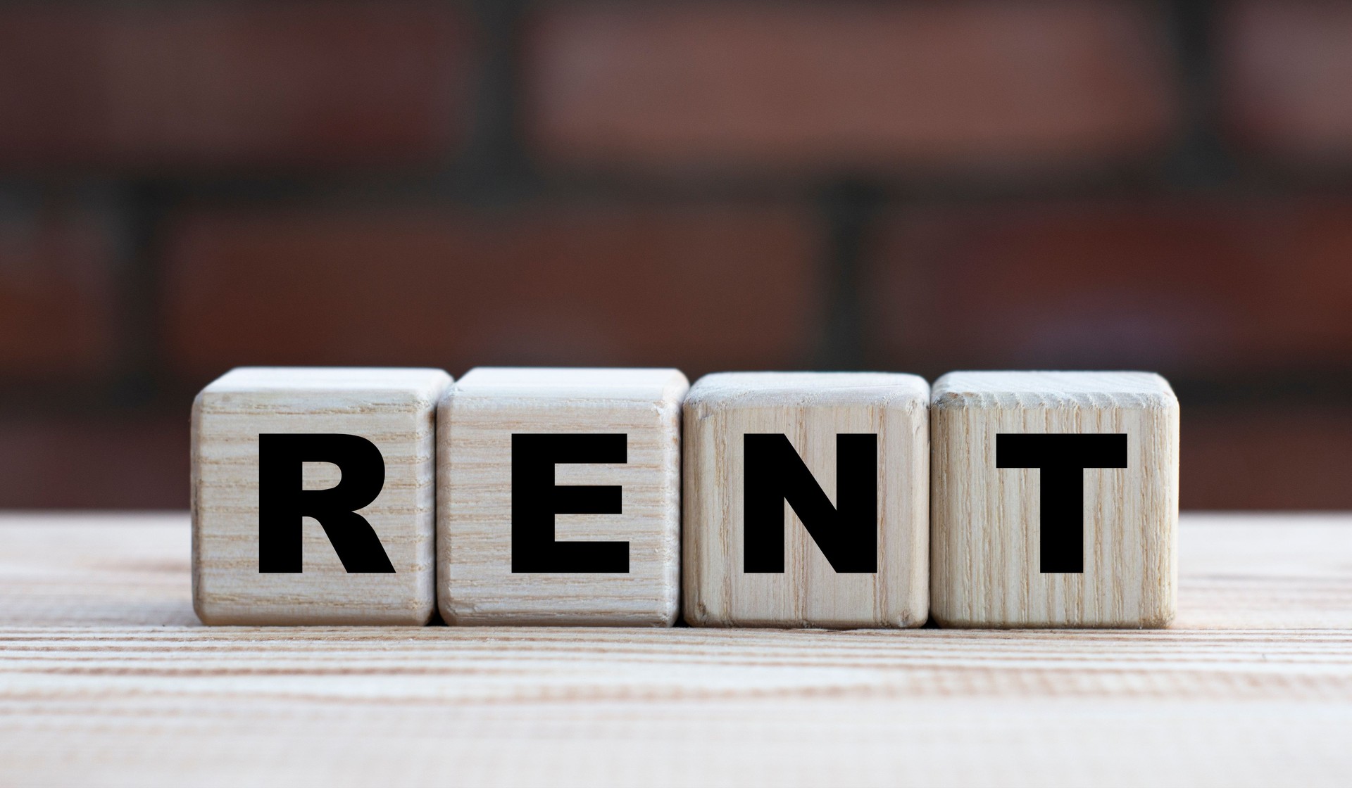 concept mot RENT sur cubes sur fond d’un mur de briques